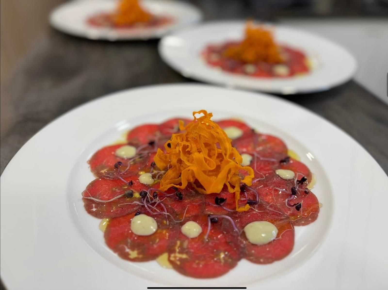 Beef carpaccio topped with crispy shoestring sweet potato and aioli